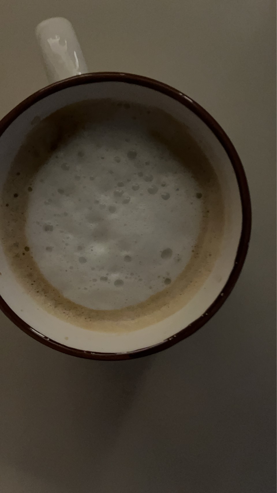 手動で泡立てたカプチーノの表面に大小の泡が見える様子